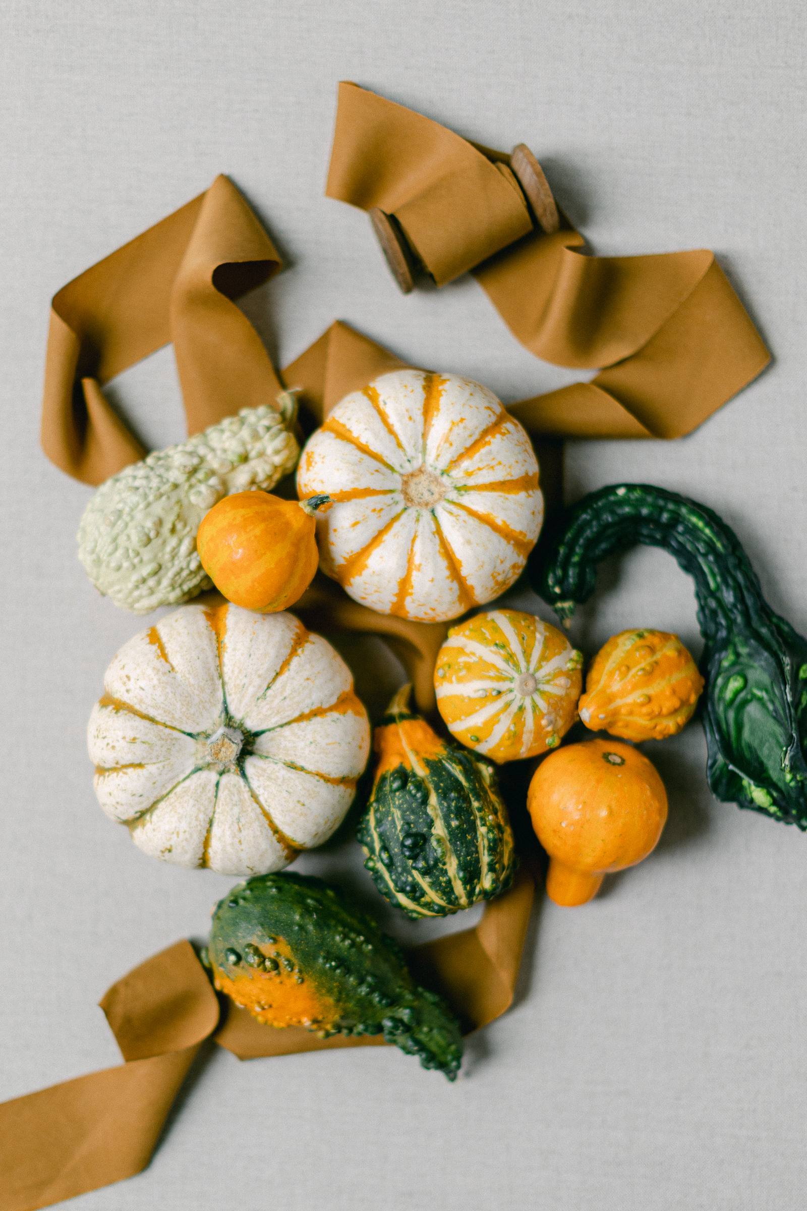 flat lay image of a variety of heirloom pumpkins on a light linen backdrop